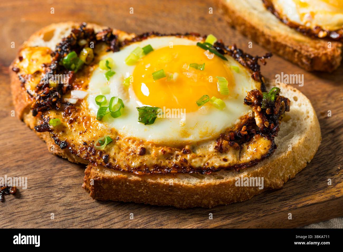 Uova fritte con olio croccante al peperoncino sano su pane tostato Foto Stock