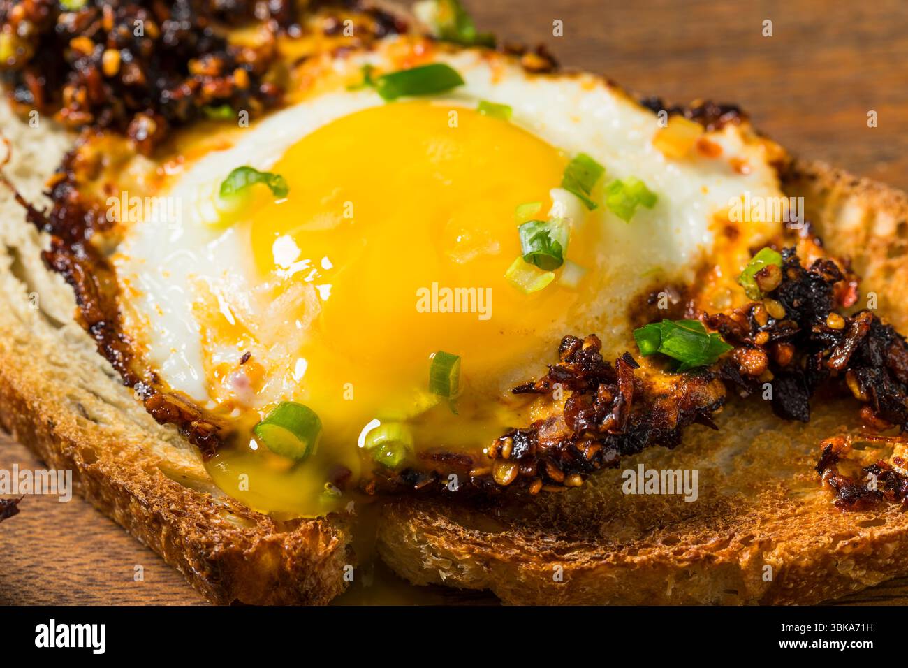 Uova fritte con olio croccante al peperoncino sano su pane tostato Foto Stock