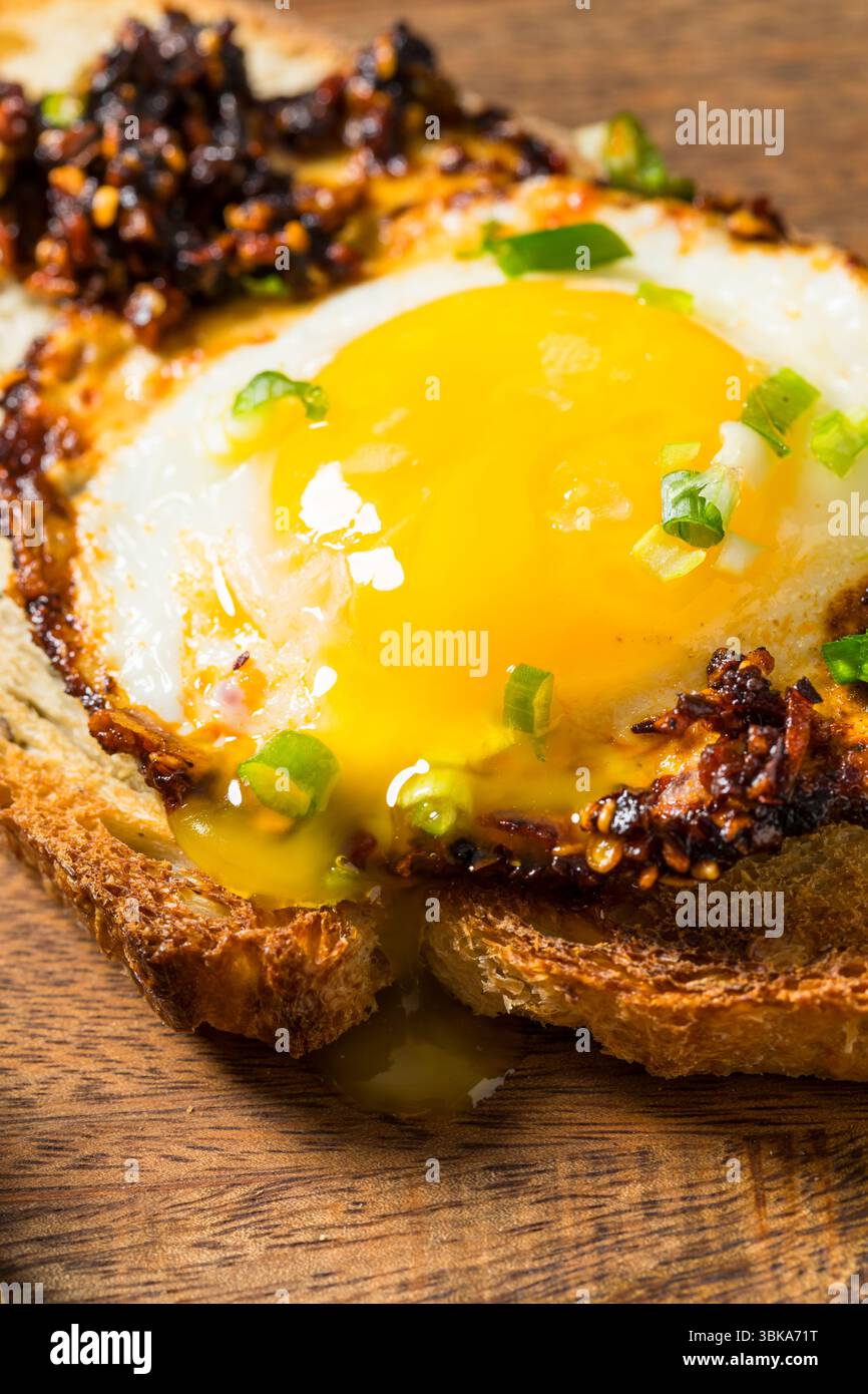 Uova fritte con olio croccante al peperoncino sano su pane tostato Foto Stock