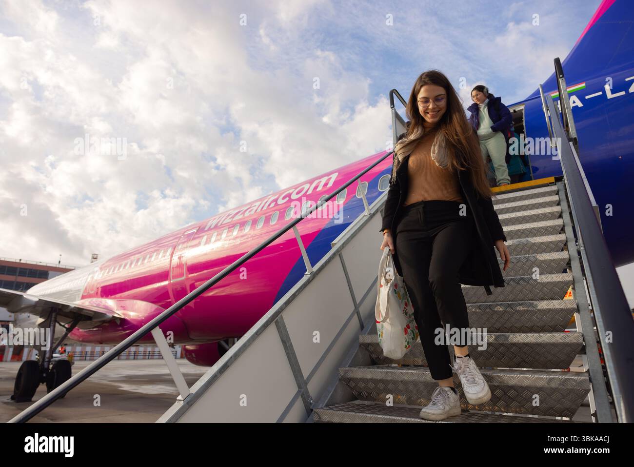 Giovane donna che scende dalle scale dell'aereo con un angolo di ripresa Foto Stock