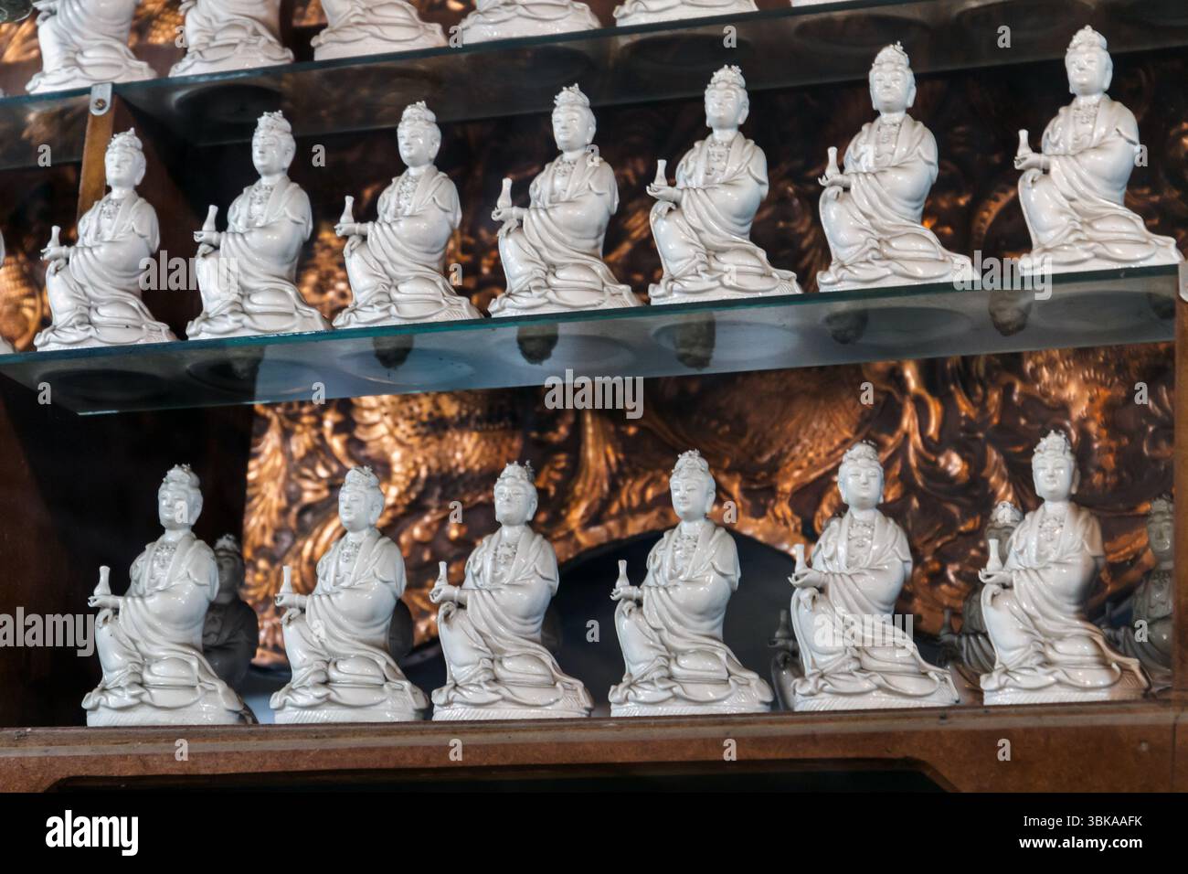 File di statuette in ceramica lavorate in modo complesso, che rappresentano forme spirituali, disposte su scaffali in un'ambientazione dettagliata. Tempio Gangaramaya di Foto Stock