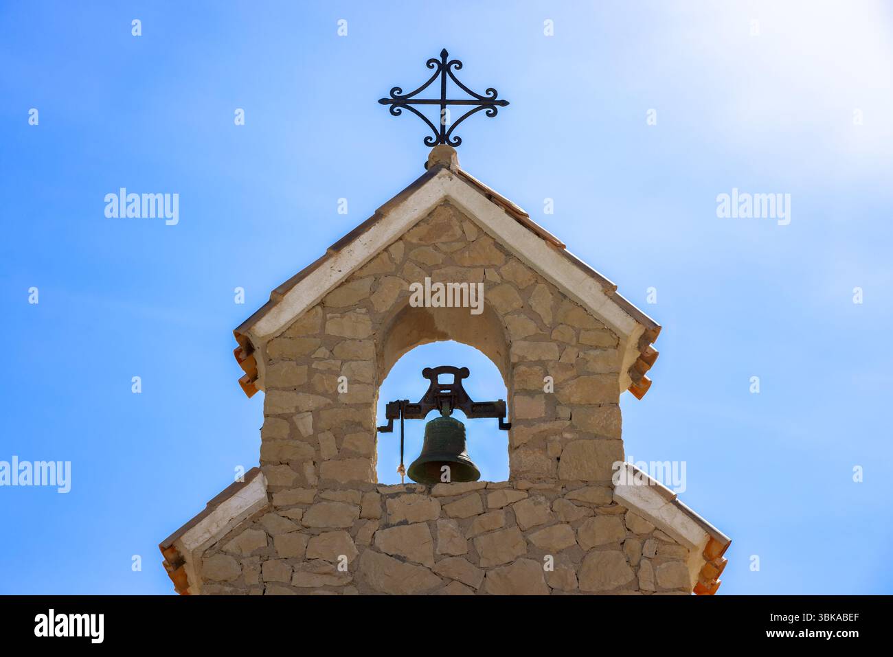 Piccola torre con campanella all'interno contro il cielo blu Foto Stock