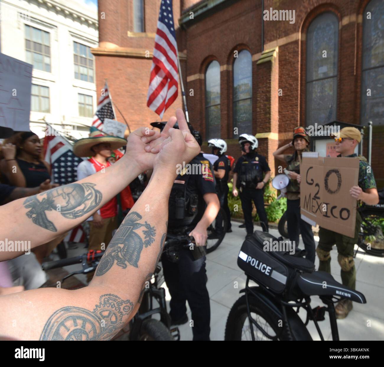 La polizia di Raleigh protegge due manifestanti anti anti-No King, uno con un corno di toro e l'altro con un cartello sul Messico Foto Stock