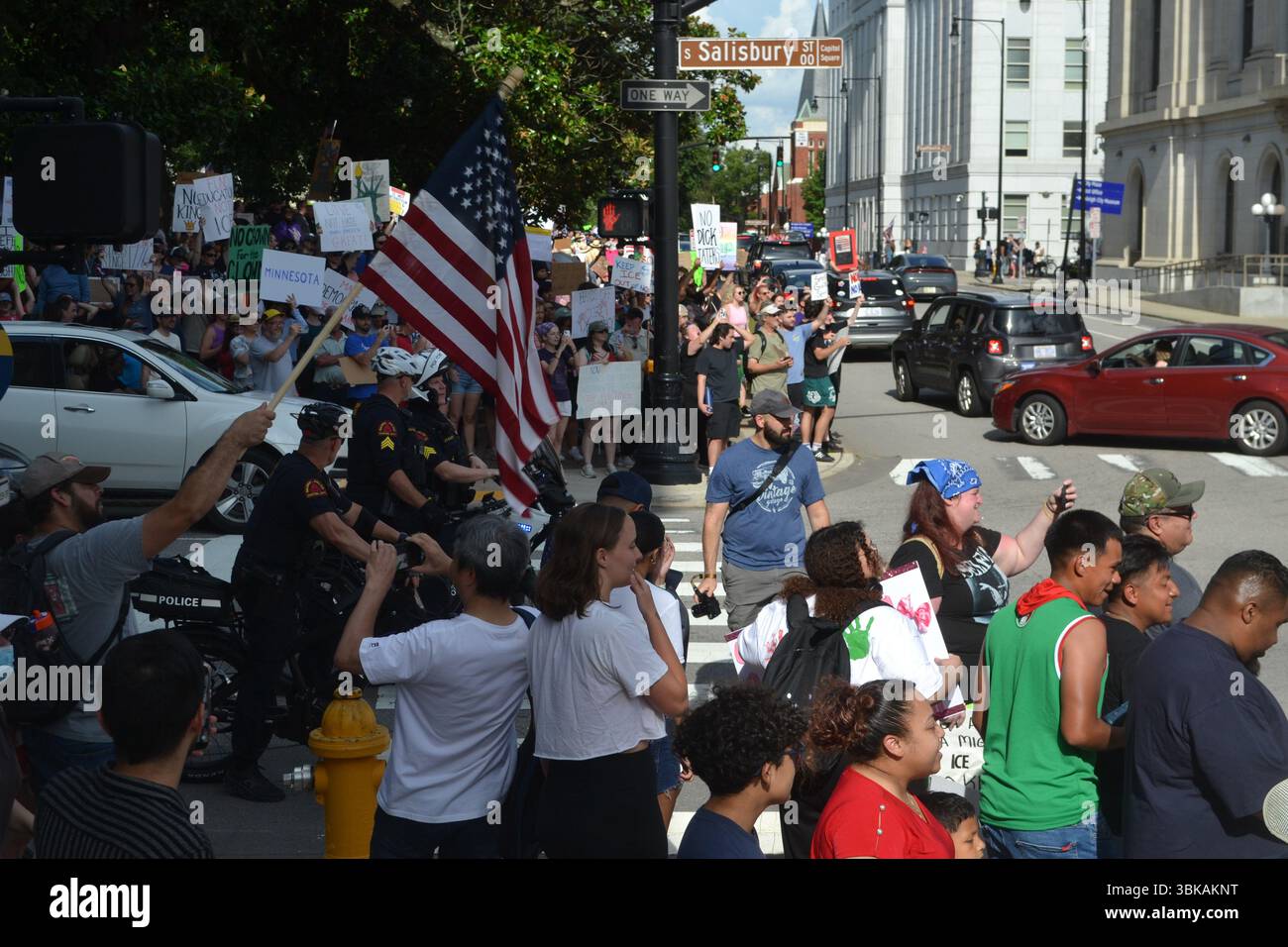 La polizia di Raleigh costituisce una barriera per proteggere due contro-manifestanti al NO KINGS RALLY a Capitol Square, nel centro di Raleigh, Carolina del Nord. Foto Stock