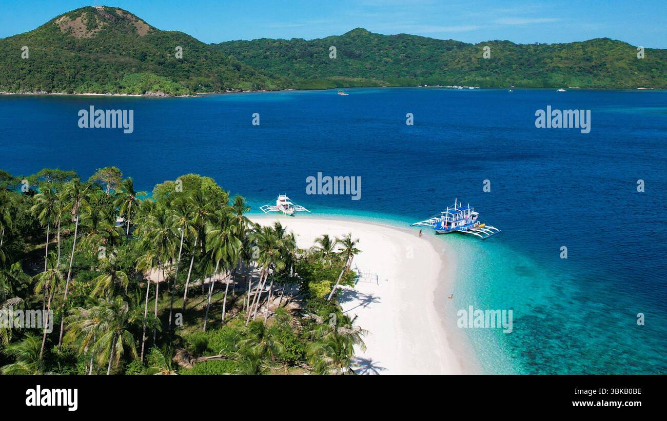 Spiaggia di sabbia rosa, acque turchesi, isola remota - Vista aerea di un'isola vergine a Linapacan, Palawan, con morbida sabbia rosa, acqua cristallina, a. Foto Stock