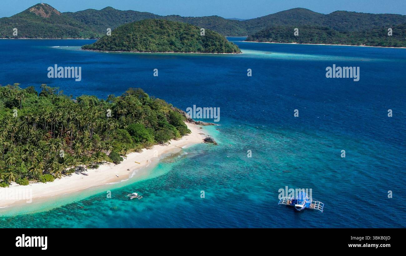 Spiaggia di sabbia rosa, acque turchesi, isola remota - Vista aerea di un'isola vergine a Linapacan, Palawan, con morbida sabbia rosa, acqua cristallina, a. Foto Stock