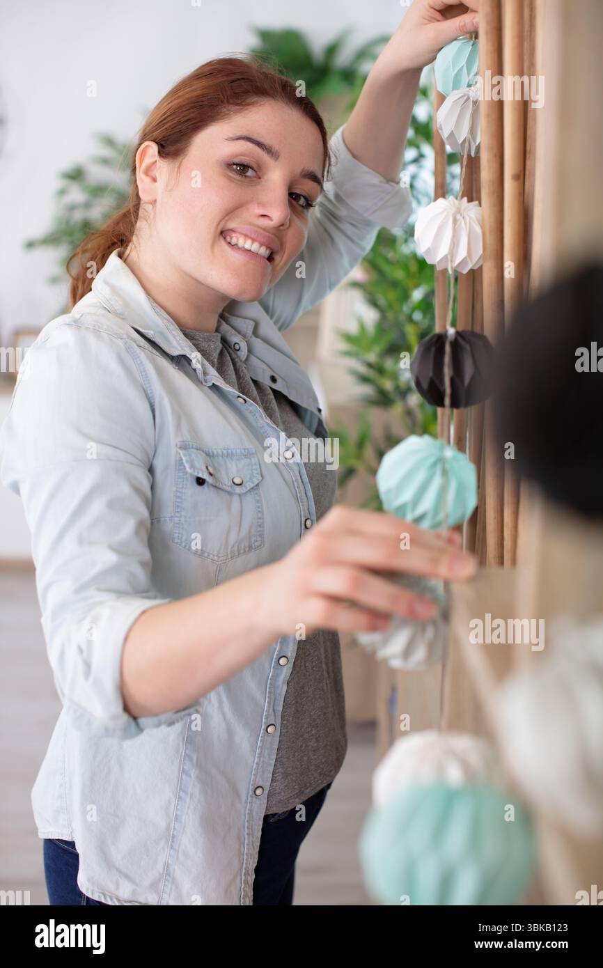bella giovane donna che decora la casa con le luci Foto Stock