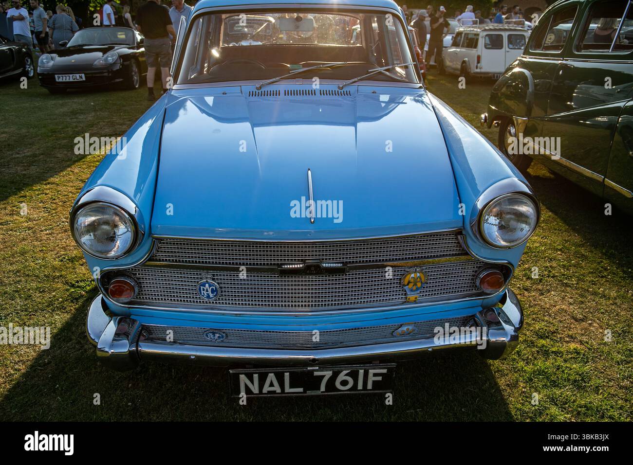 Vista frontale di un'auto Austin A60 blu d'epoca esposta in una mostra di auto d'epoca con altri veicoli e persone sullo sfondo Foto Stock