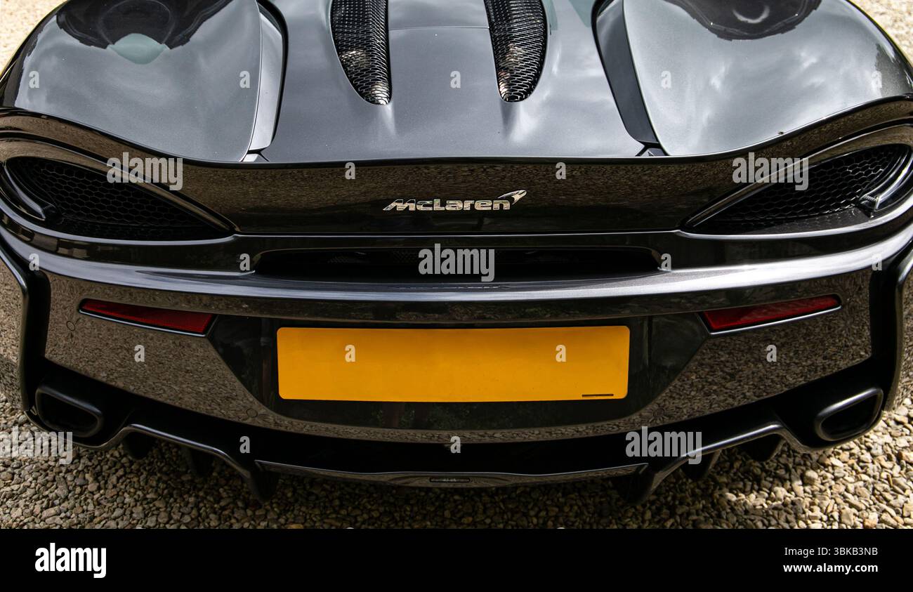 Immagine ravvicinata di un'elegante vettura sportiva nera con particolare attenzione al design aerodinamico e agli eleganti sistemi di scarico Foto Stock