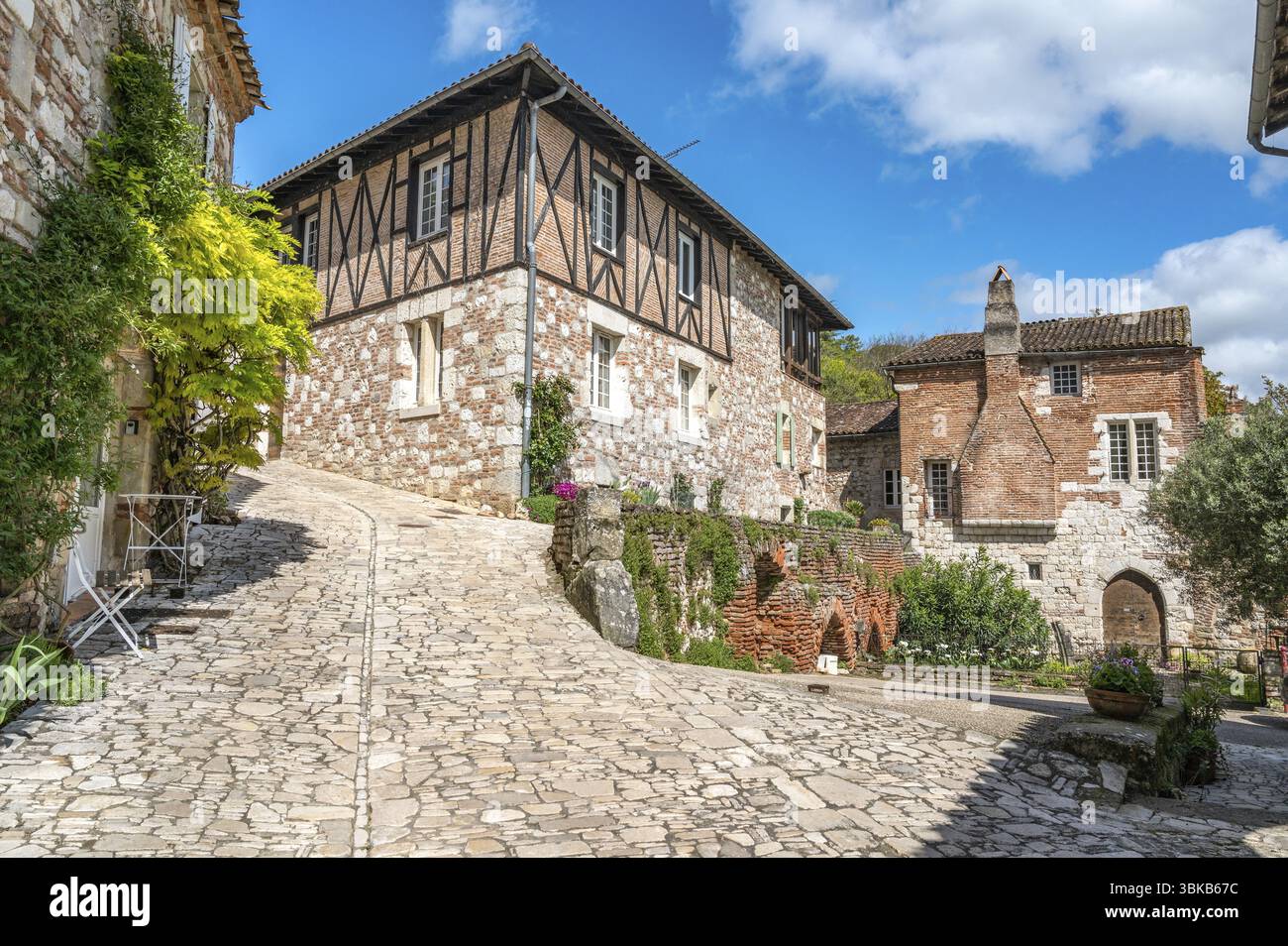 Edifici medievali in Rue de Ferracap con facciate in pietra naturale e mattoni in uno dei villaggi più belli della Francia, penne-d'Agenais, Departe Foto Stock