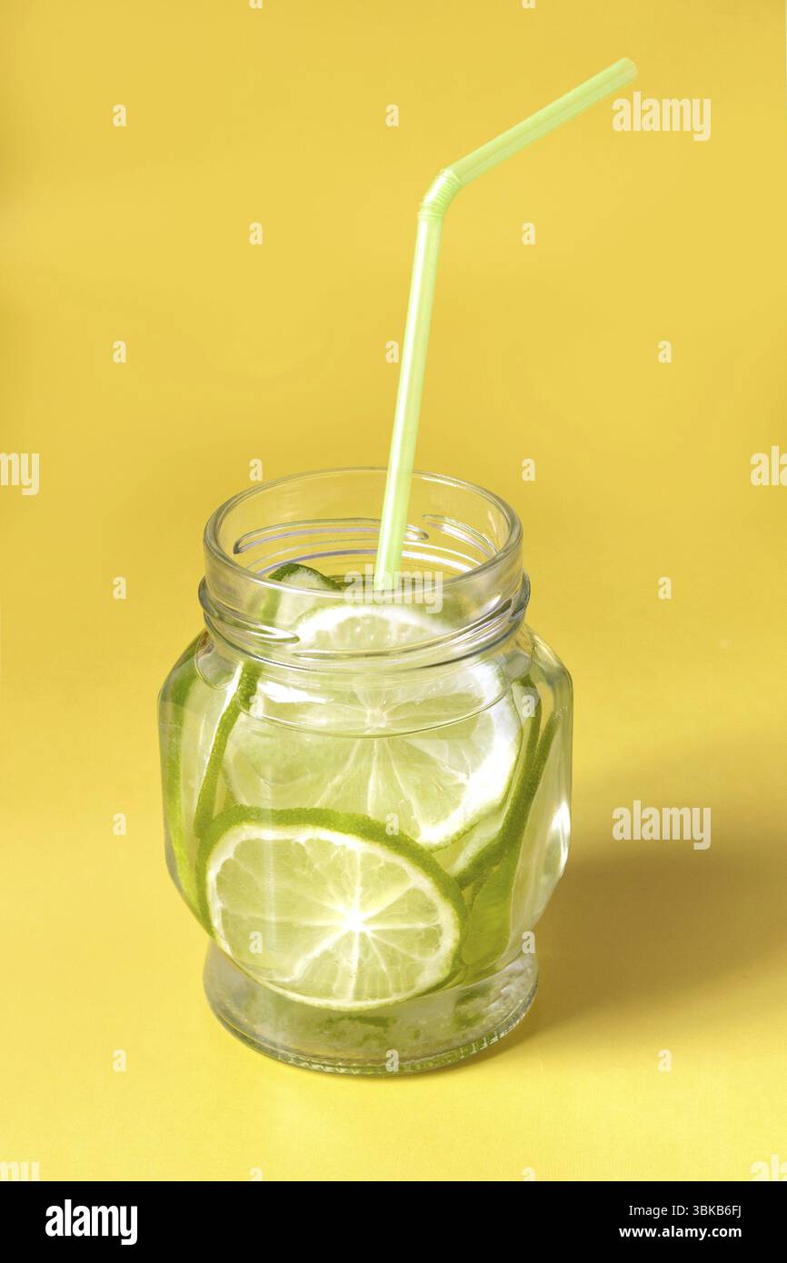 Acqua con spicchi di lime in un vaso di vetro con paralume Foto Stock