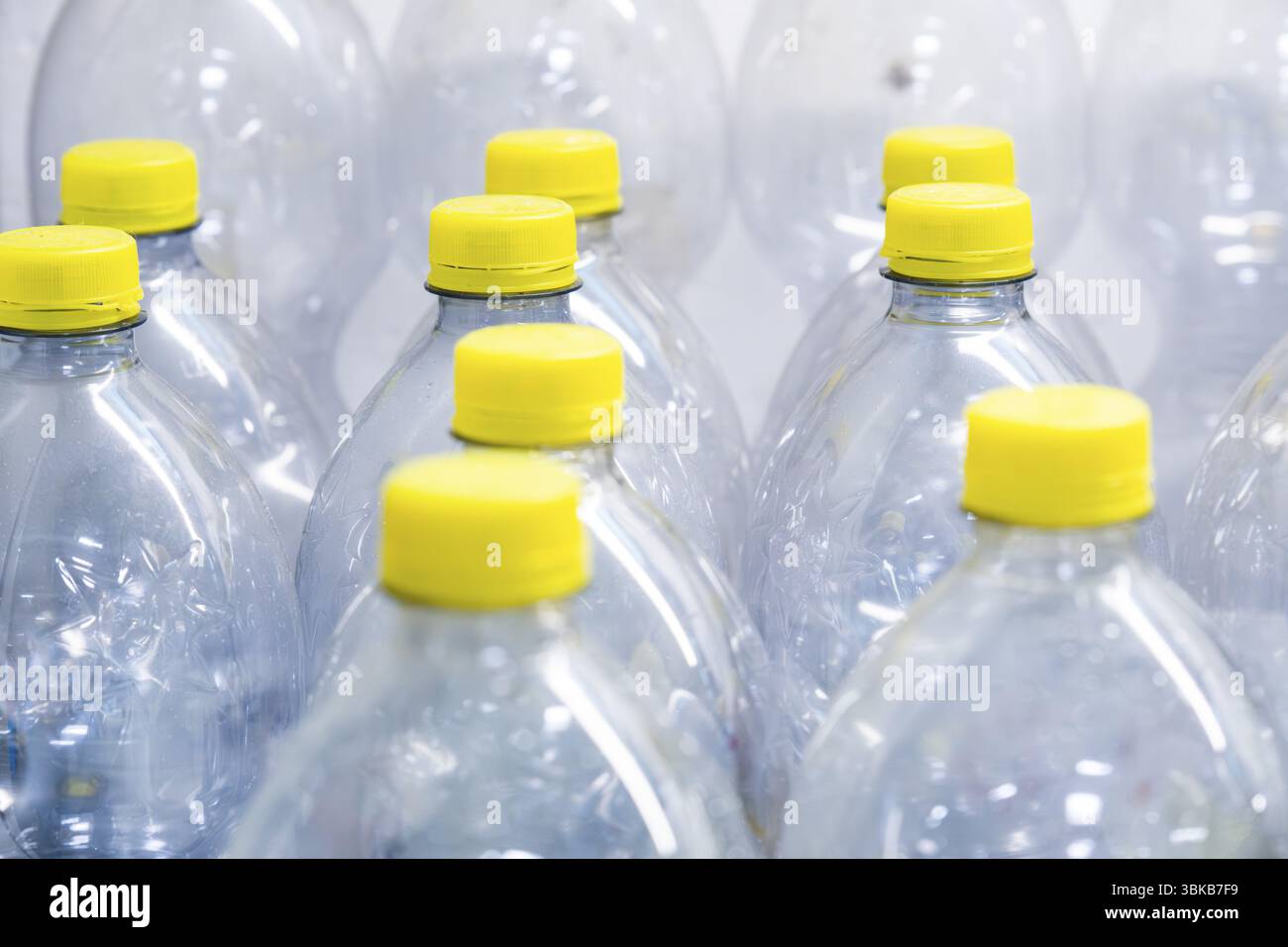 Una raccolta di flaconi in plastica trasparente con tappi a vite gialli Foto Stock