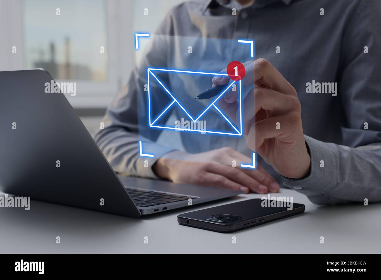 Marketing via e-mail, notifica di nuovi messaggi. Uomo che usa lo schermo virtuale sopra il laptop a tavola, primo piano Foto Stock