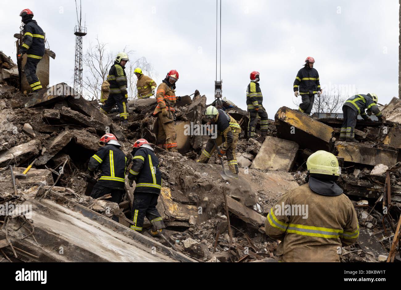 I vigili del fuoco cercano tra le macerie di un edificio distrutto a seguito di un evento significativo, mostrando gli sforzi nelle operazioni di recupero critiche Foto Stock
