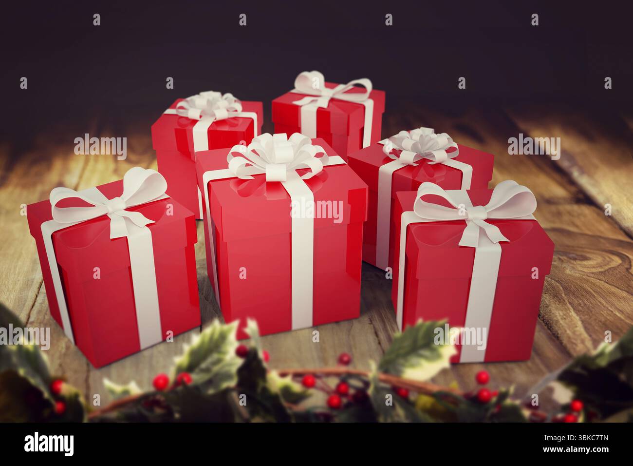 Cinque scatole rosse con archi bianchi sono sedute su un tavolo in legno dal design piatto con holly Foto Stock
