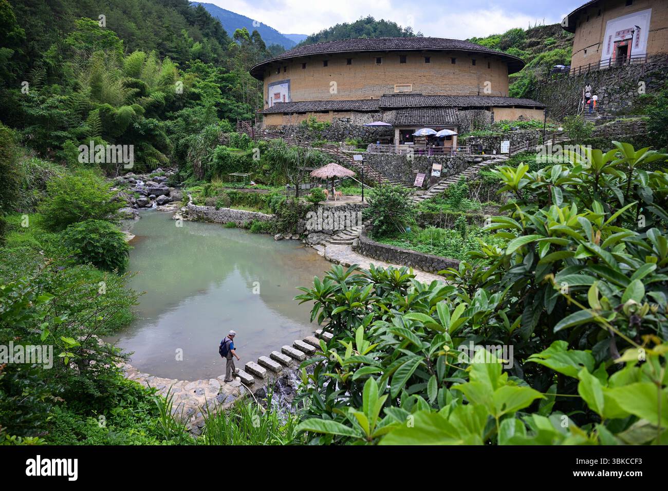 (250620) -- LONGYAN, 20 giugno 2025 (Xinhua) -- Un turista visita l'ammasso Chuxi Tulou a Longyan, nella provincia del Fujian della Cina sud-orientale, 22 maggio 2025. Fujian Tulou, l'architettura residenziale unica della provincia di Fujian costruita tra il XV e il XX secolo, è stata iscritta nella lista del patrimonio mondiale dell'UNESCO nel 2008. Situato tra campi di riso, tè e tabacco, Tulou è una casa di terra. Alto diversi piani, è stato costruito su una pianta circolare o quadrata dall'interno per ospitare fino a 800 persone ciascuna. Tulou fu costruita per scopi difensivi intorno ad un cortile centrale aperto con onl Foto Stock