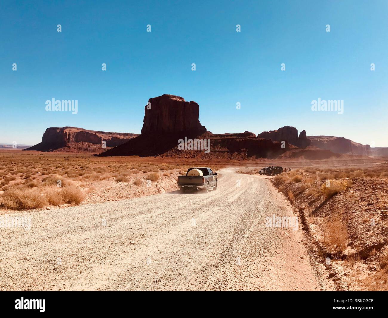 Desert Road e Monument Valley Buttes, confine tra Arizona e Utah Foto Stock