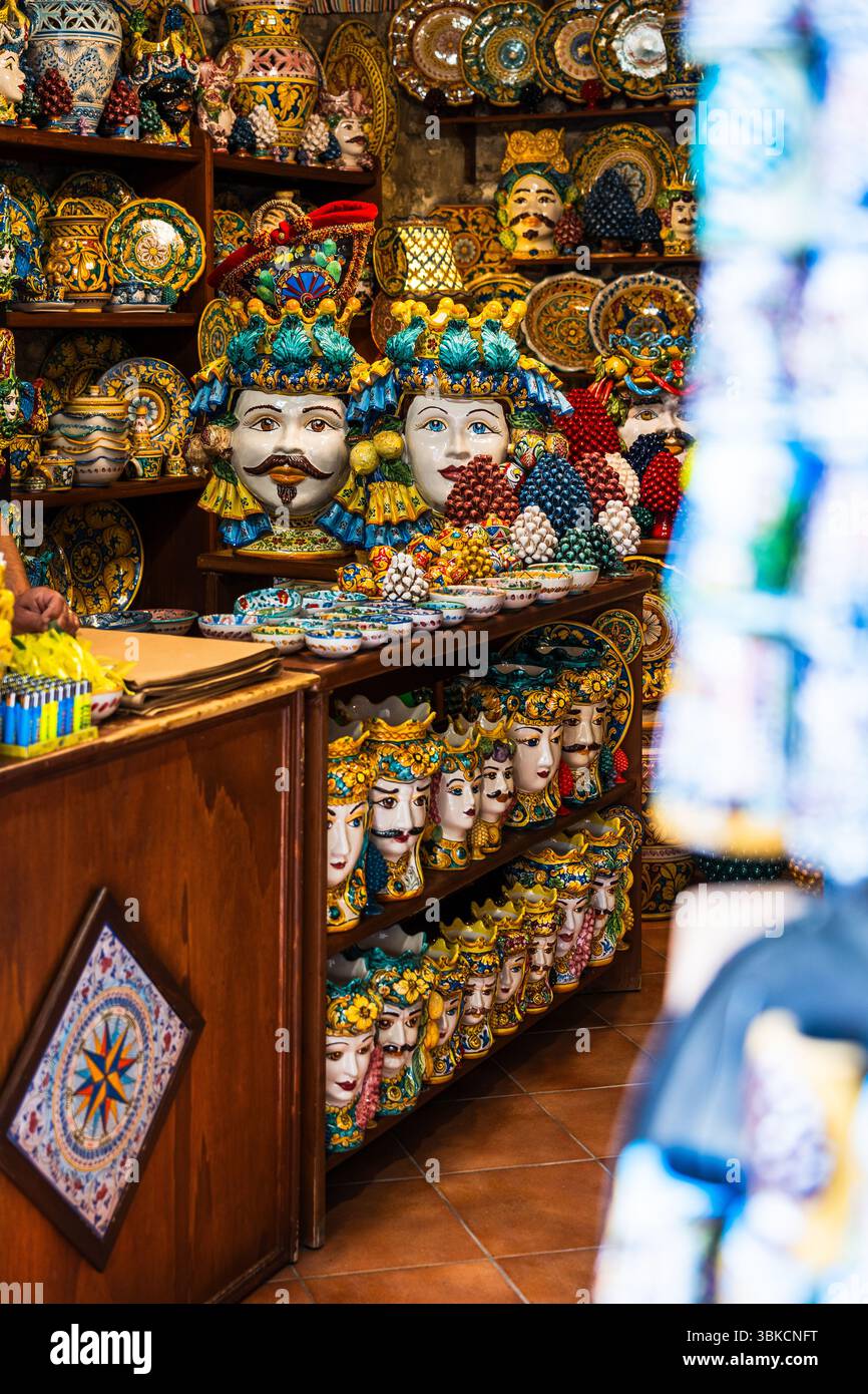 Teste e ceramiche tradizionali siciliane esposte in un colorato negozio di artigianato Foto Stock