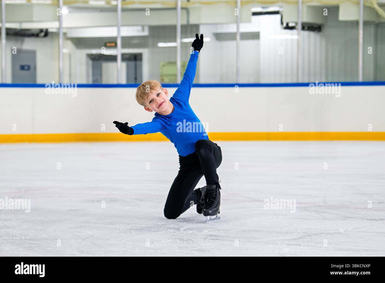 pattinatore di figura ragazzo pattina su una pista coperta, dimostrando equilibrio . Foto Stock