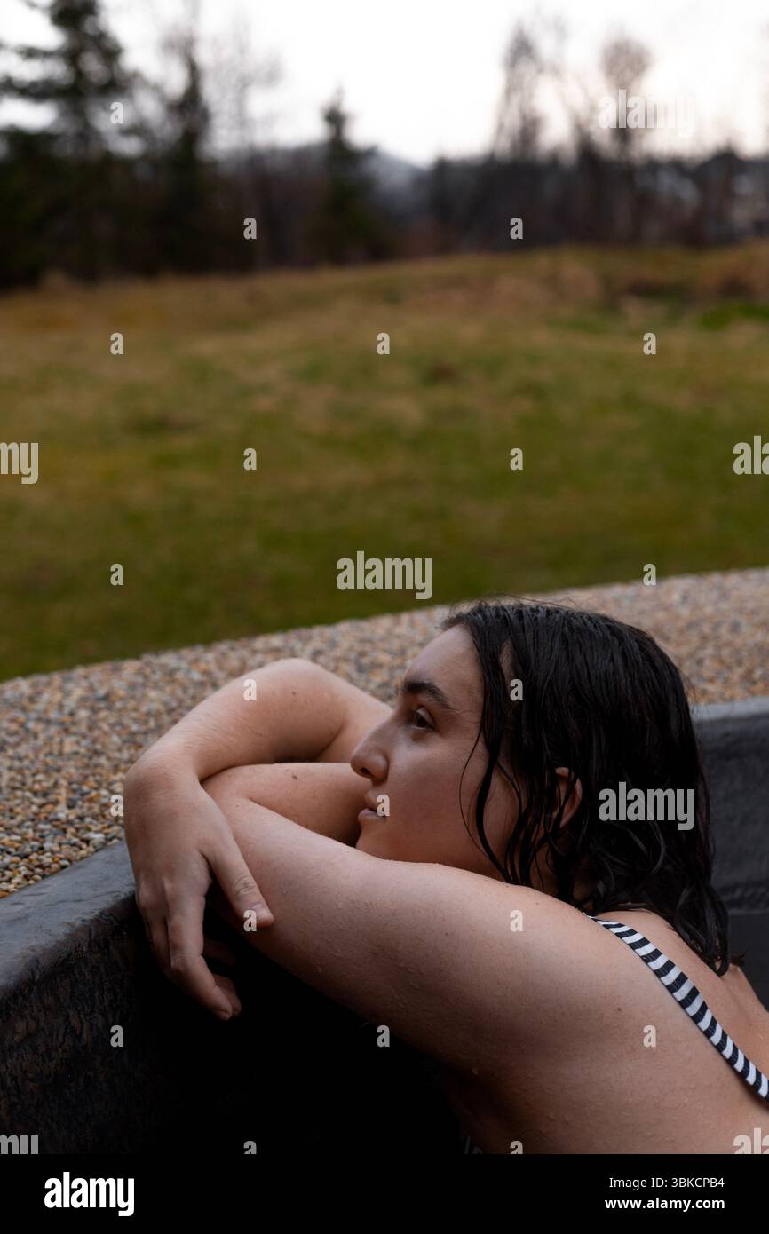 una donna riposante durante un'attenta immersione nella vasca idromassaggio. Foto Stock