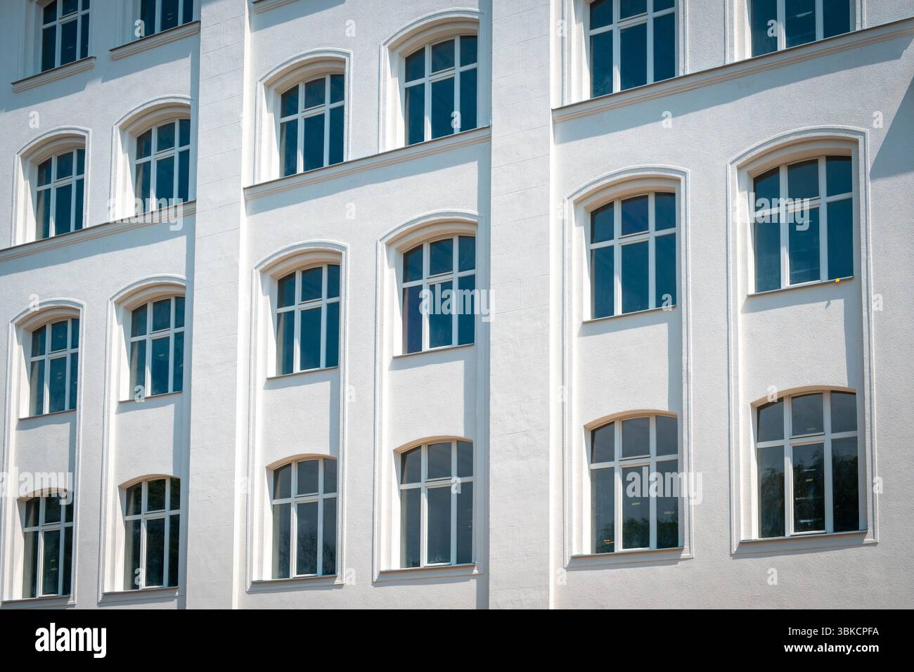 finestre su facciata bianca pulita di un edificio residenziale, esterno immobiliare, Foto Stock