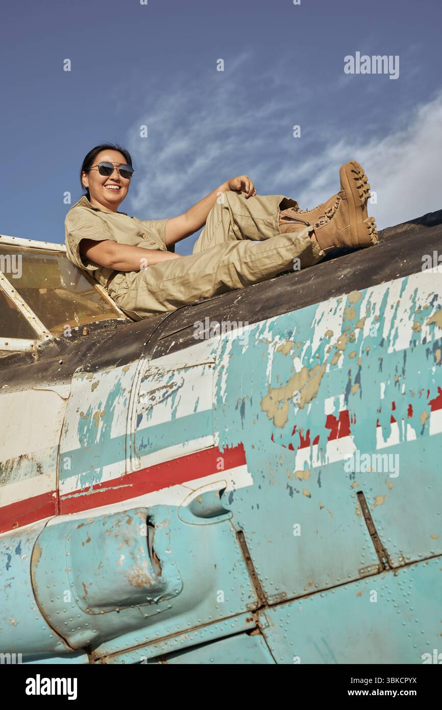Una donna siede sull'ala di un aereo Foto Stock