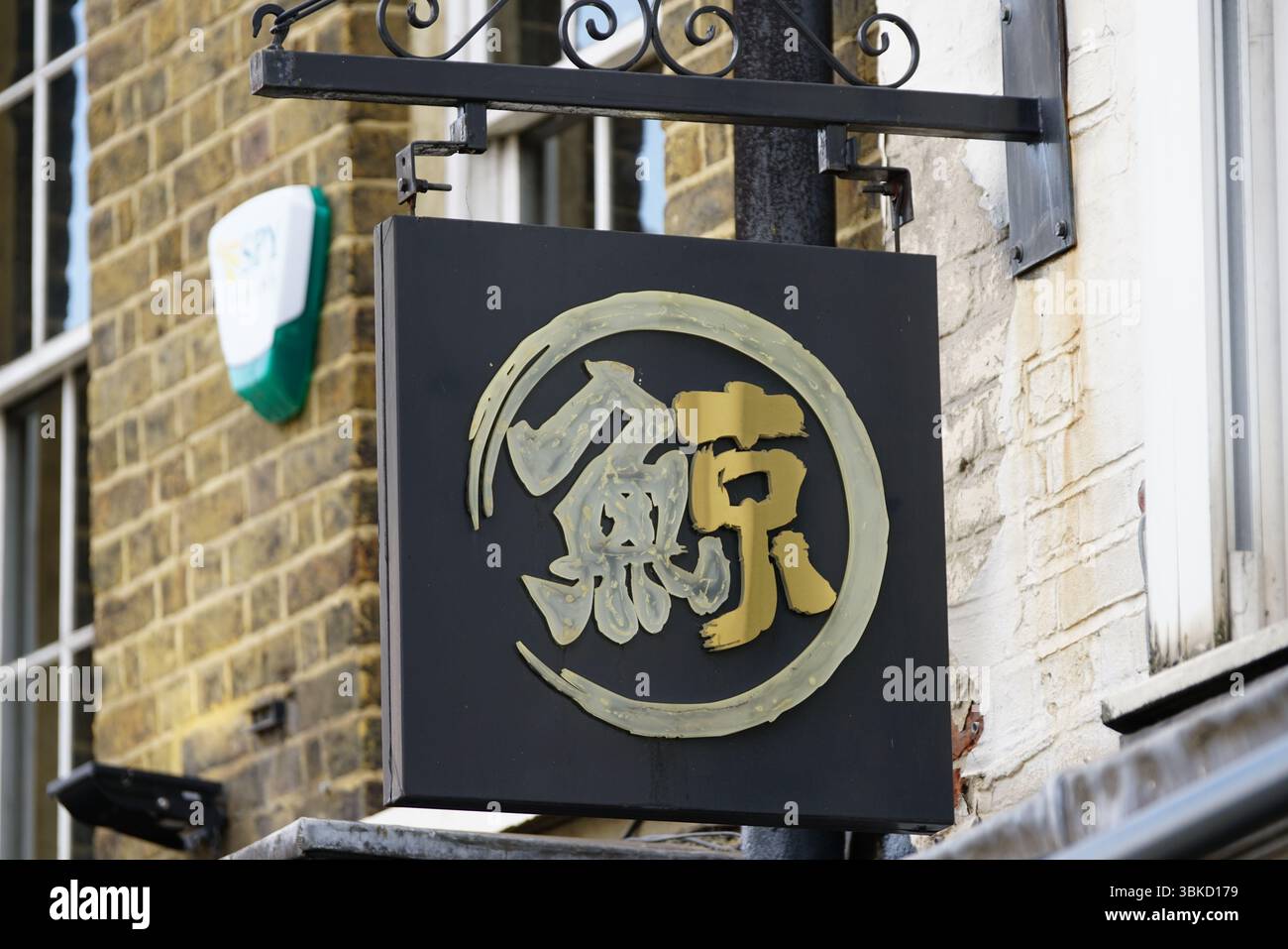 Primo piano di un cartello asiatico con calligrafia dorata e bianca. Greenwich, Londra, Inghilterra Foto Stock