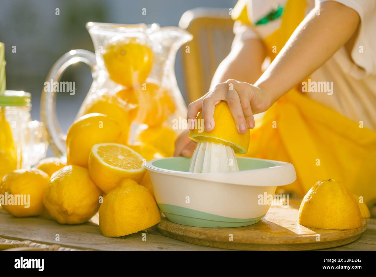 Spremiagrumi per bambini con una centrifuga manuale, per preparare freschi succhi di agrumi per una sana bevanda estiva, luminosa e naturale. Foto Stock
