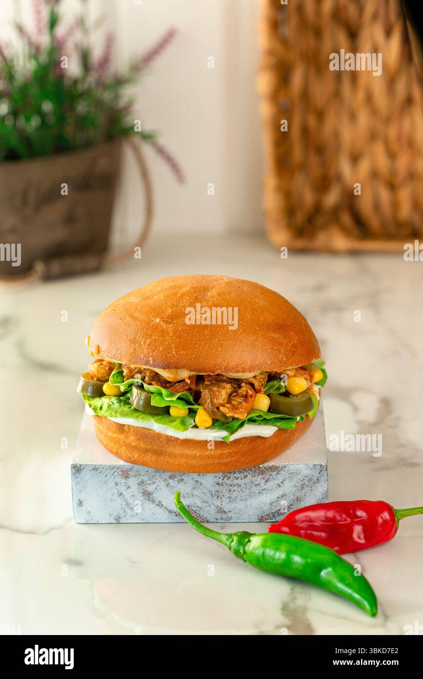 Speciale pane hamburger con lattuga di mais e pezzi di pollo. Foto Stock