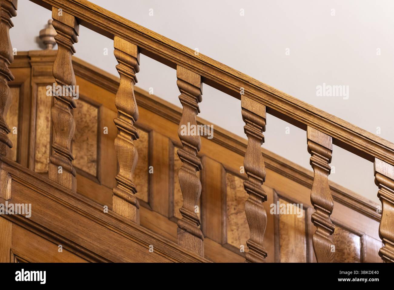 Elegante primo piano di una scala in legno splendidamente intagliata che mostra dettagli intricati e maestria artigianale, caratterizzata da un'elegante e ben curata Foto Stock