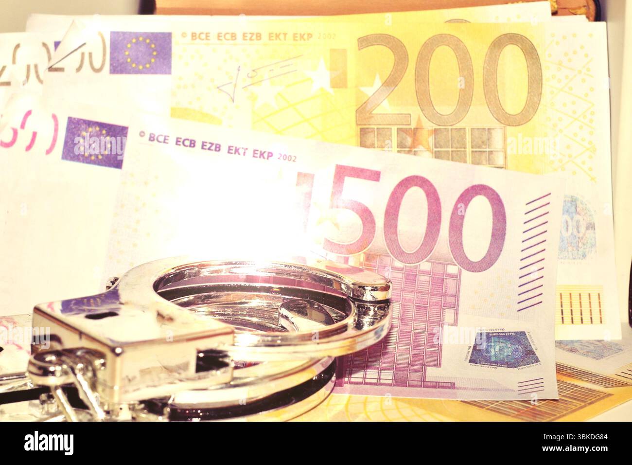 Banconote in euro e manette metalliche, concetto di criminalità finanziaria Foto Stock