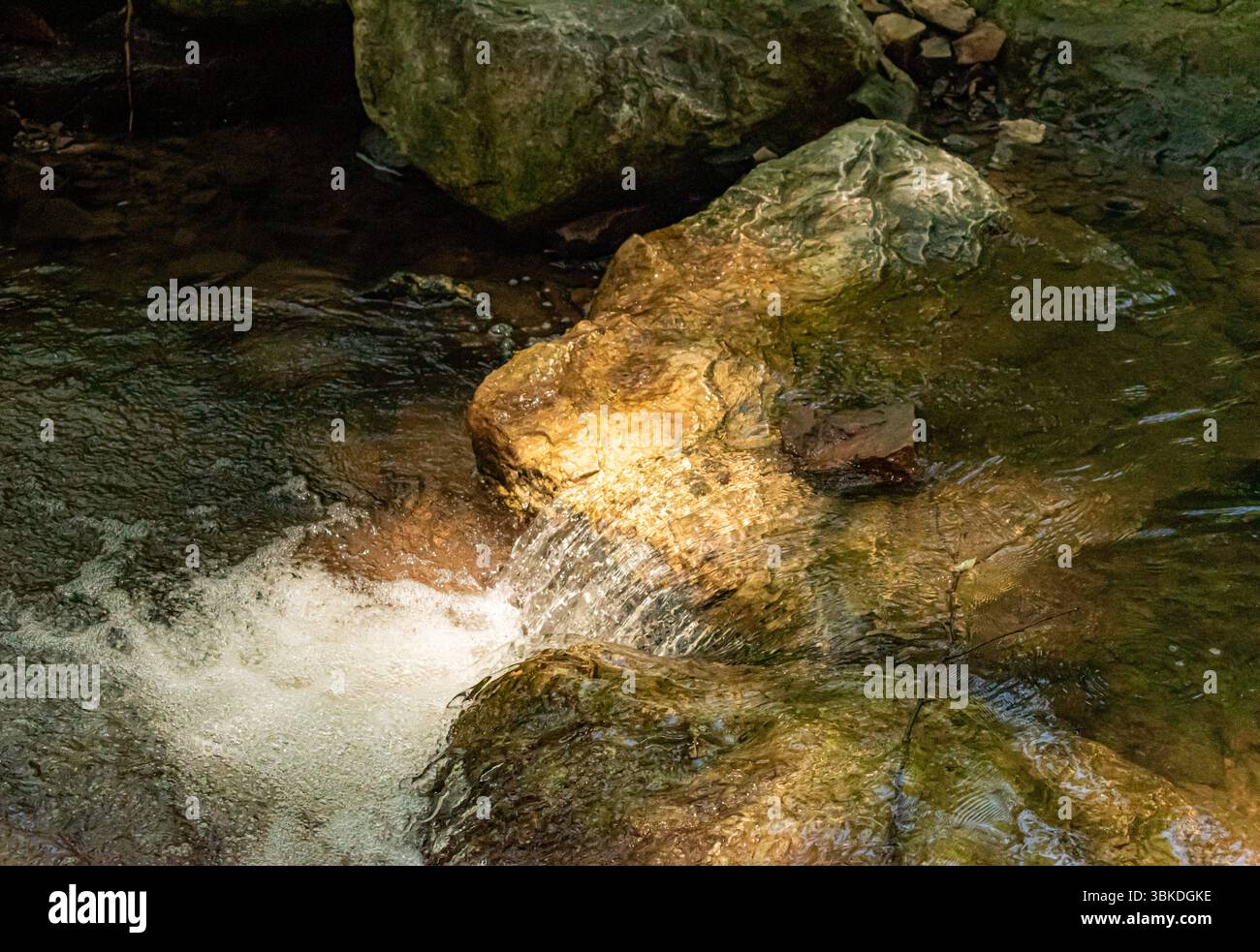 acqua tranquilla che scorre a valle sopra le rocce Foto Stock
