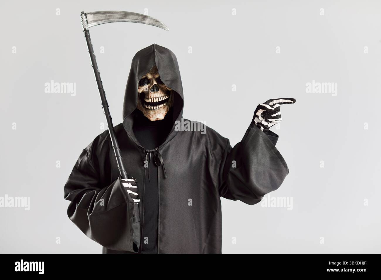 Ritratto di uomo inquietante a immagine di morte con la falce che punta il dito a fianco. Foto Stock