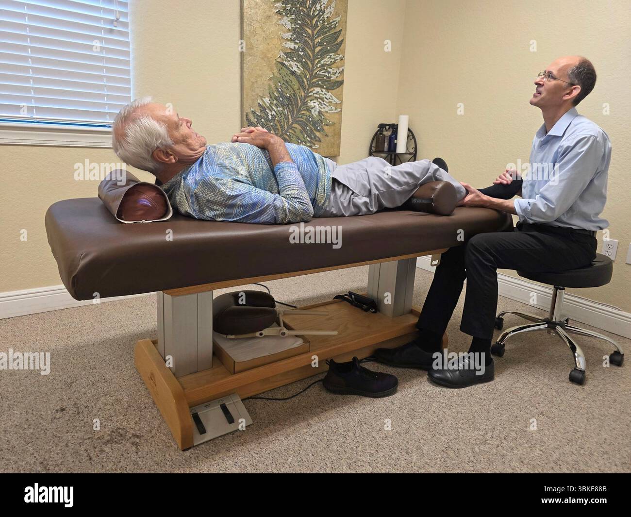 Il chiropratico che applica la terapia miofasciale allevia questo dolore esercitando una leggera pressione sui muscoli doloranti per un periodo di tempo prolungato. Venice FL Foto Stock