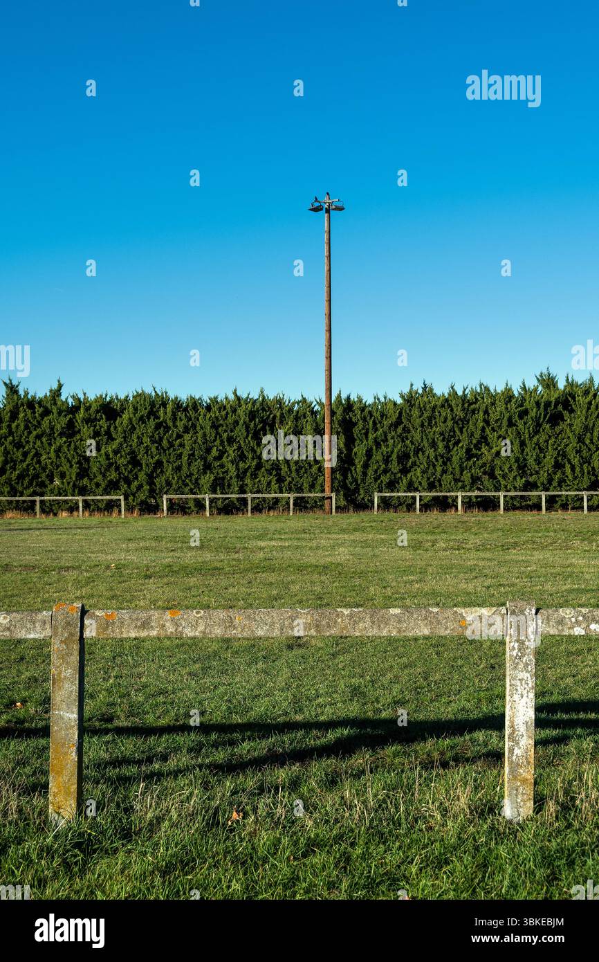 Campo da calcio rurale circondato dal verde e dal cielo azzurro in una giornata di sole. Puy de Dome, Auvergne, Francia Foto Stock