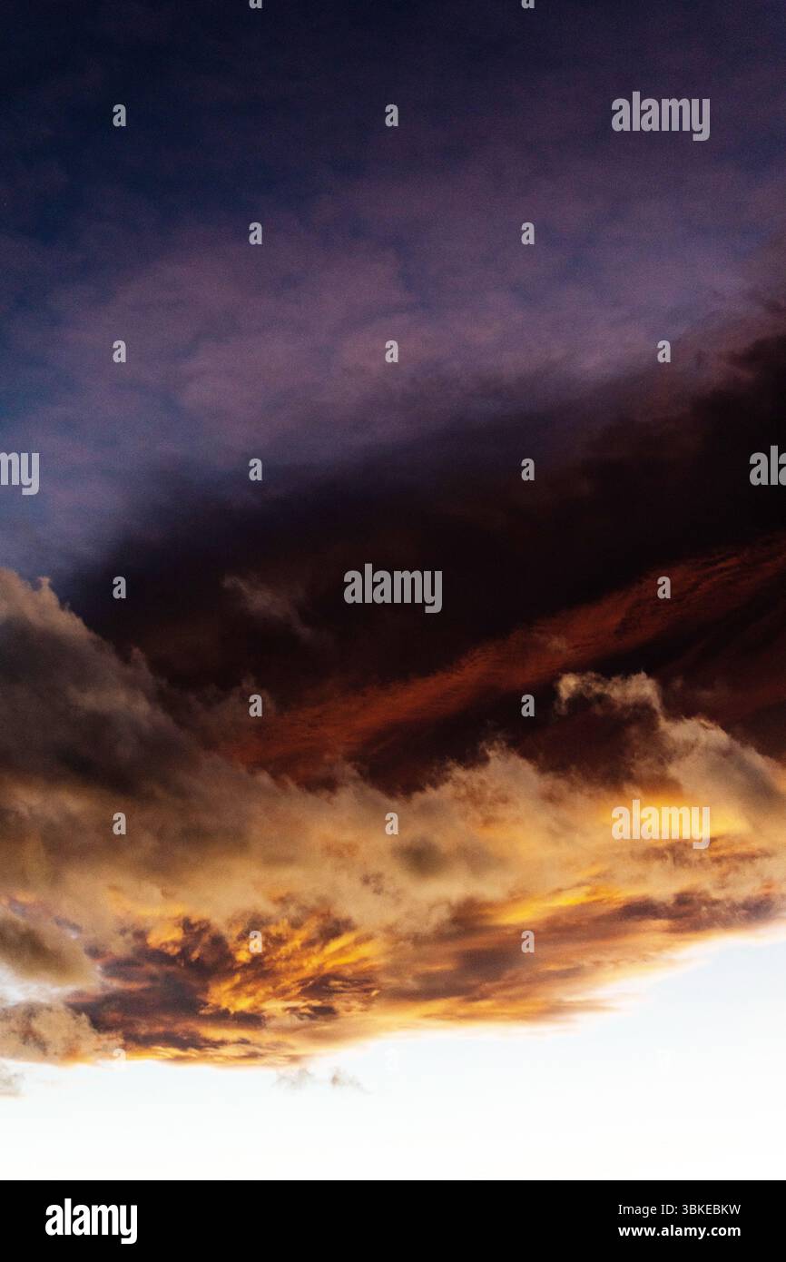 Un'incredibile esposizione di nuvole al tramonto mostra colori arancioni e viola profondi che sbiadono nel cielo notturno. Foto Stock