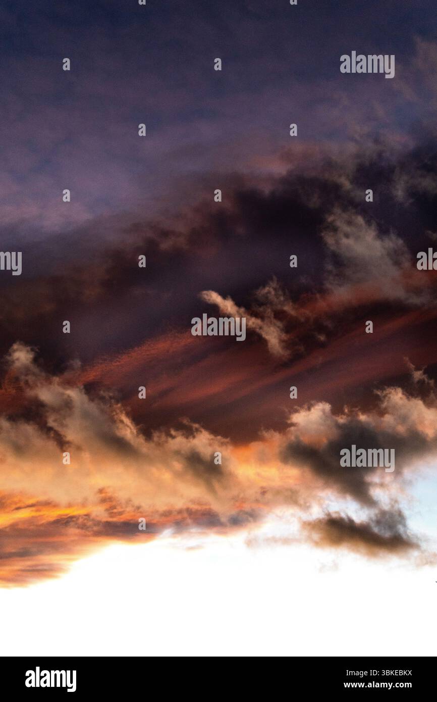 Le nuvole vibranti sono illuminate dal sole che tramonta, mostrando una miscela di colori e texture nel cielo. Foto Stock