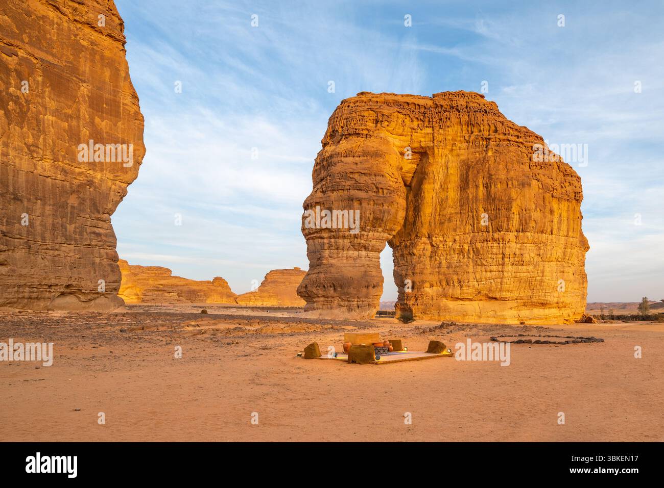 Le persone si rilassano al bar al tramonto presso l'iconica Elephant Rock of Alula, un'incredibile formazione rocciosa di arenaria, una meraviglia naturale in mezzo al paesaggio desertico, i Foto Stock