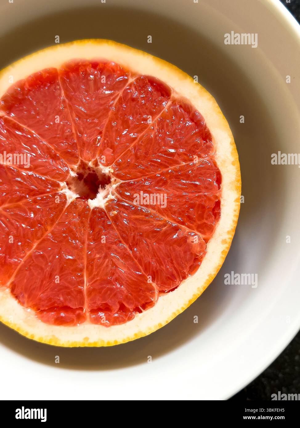 Vista ad angolo alto della metà pompelmo nel recipiente Foto Stock