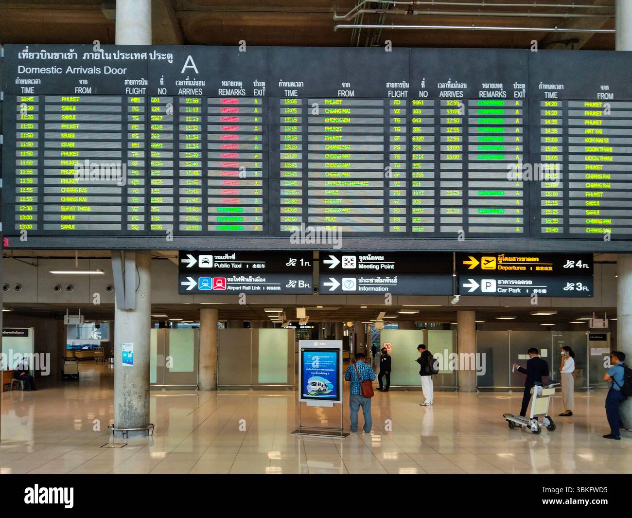 Aeroporto di Suwannabhumi, Thailandia, 14 aprile, 2024 interno dell'aeroporto con passeggeri che controllano una grande bacheca digitale per gli aggiornamenti Foto Stock