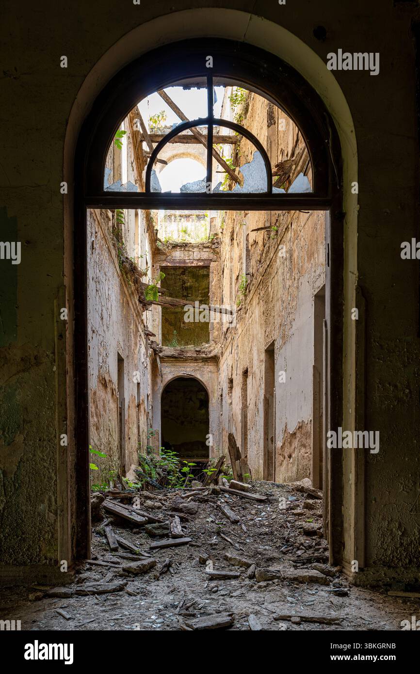Edificio abbandonato interno con rovine e vegetazione sovrastata a Tskaltubo, Georgia Foto Stock