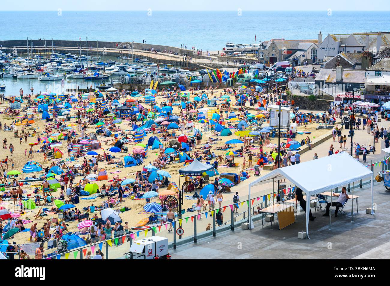 Lyme Regis, Dorset, Regno Unito. 21 giugno 2025. Meteo nel Regno Unito. La folla si è affollata in una spiaggia piena per immergersi nel caldo sole della località balneare di Lyme Regis il giorno più lungo dell'anno. Chi cerca il sole ha faticato a trovare un posto dove prendere il sole tra le sdraio e gli ombrelloni sulla spiaggia affollata. Crediti: Celia McMahon/Alamy Live News. Foto Stock