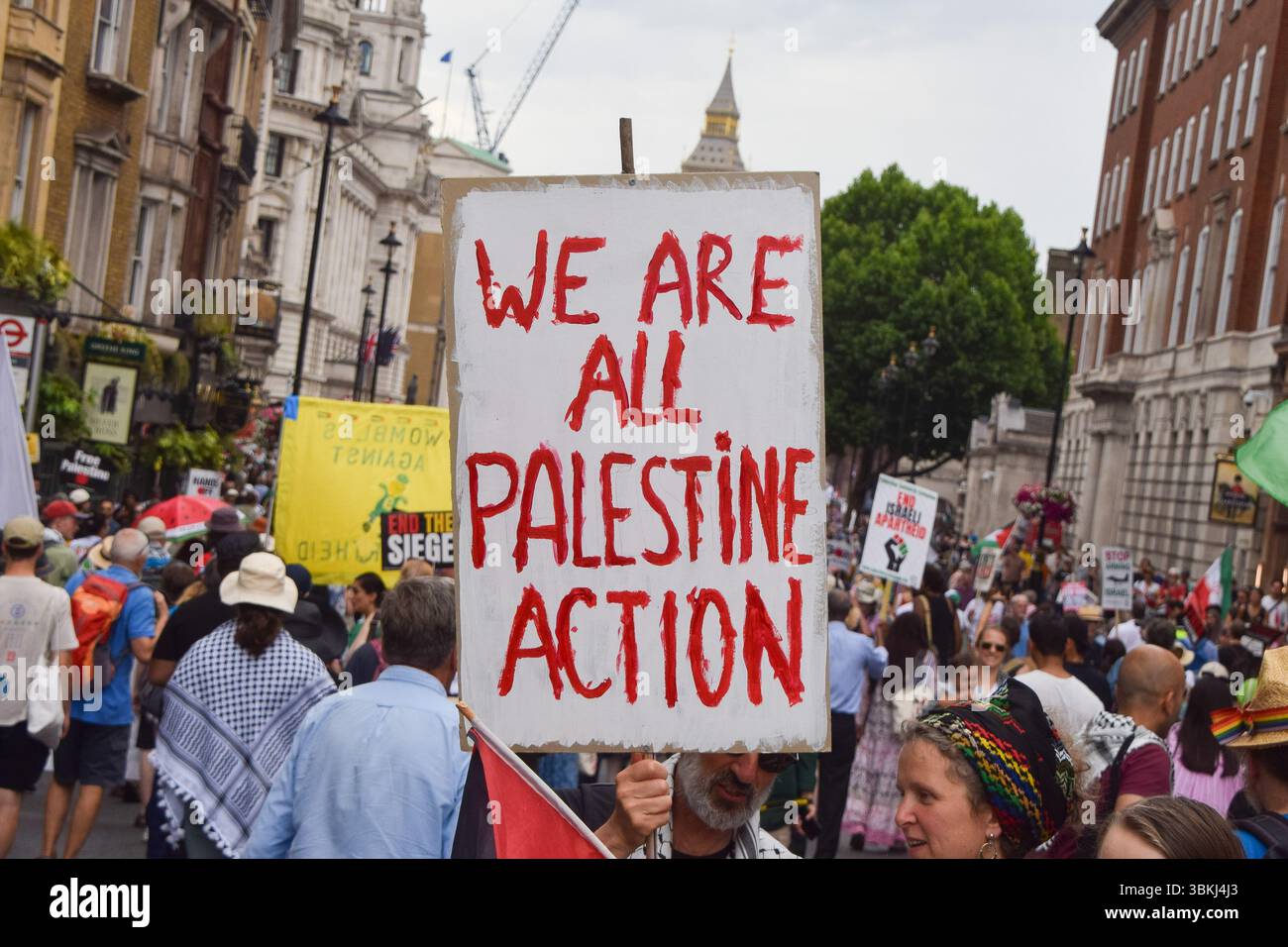 Londra, Regno Unito. 21 giugno 2025. Un manifestante tiene un cartello a sostegno del gruppo di attivisti Palestine Action durante la manifestazione a Whitehall. Decine di migliaia di persone hanno marciato nel centro di Londra a sostegno della Palestina e in segno di protesta contro i bombardamenti iraniani, mentre Israele continua i suoi attacchi a Gaza e lancia attacchi contro l'Iran. Credito: SOPA Images Limited/Alamy Live News Foto Stock
