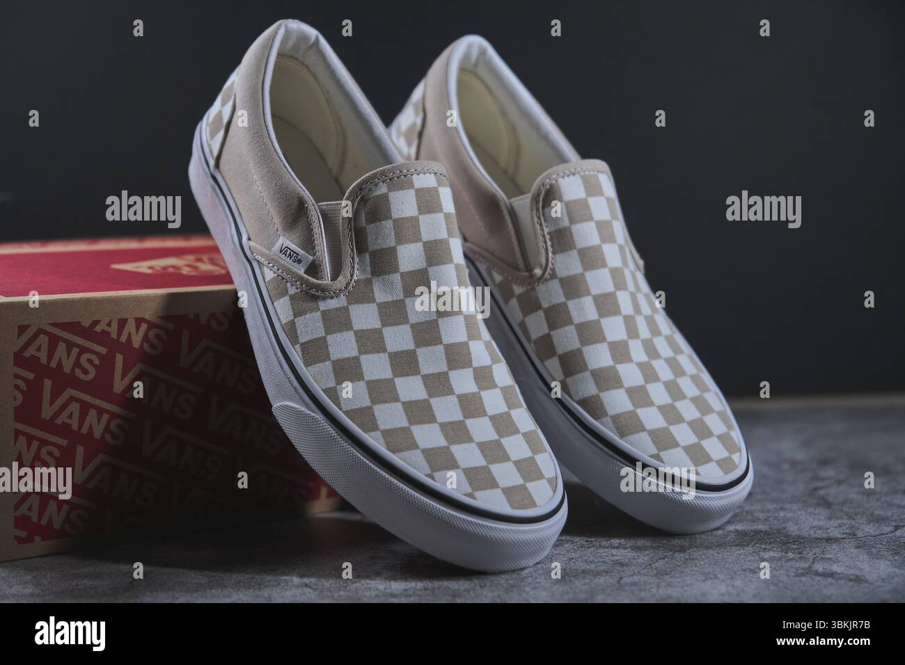 Le scarpe slip-on dei furgoni a scacchi si posizionano sulla loro scatola dopo essere state smontate, mostrando il loro design iconico Foto Stock