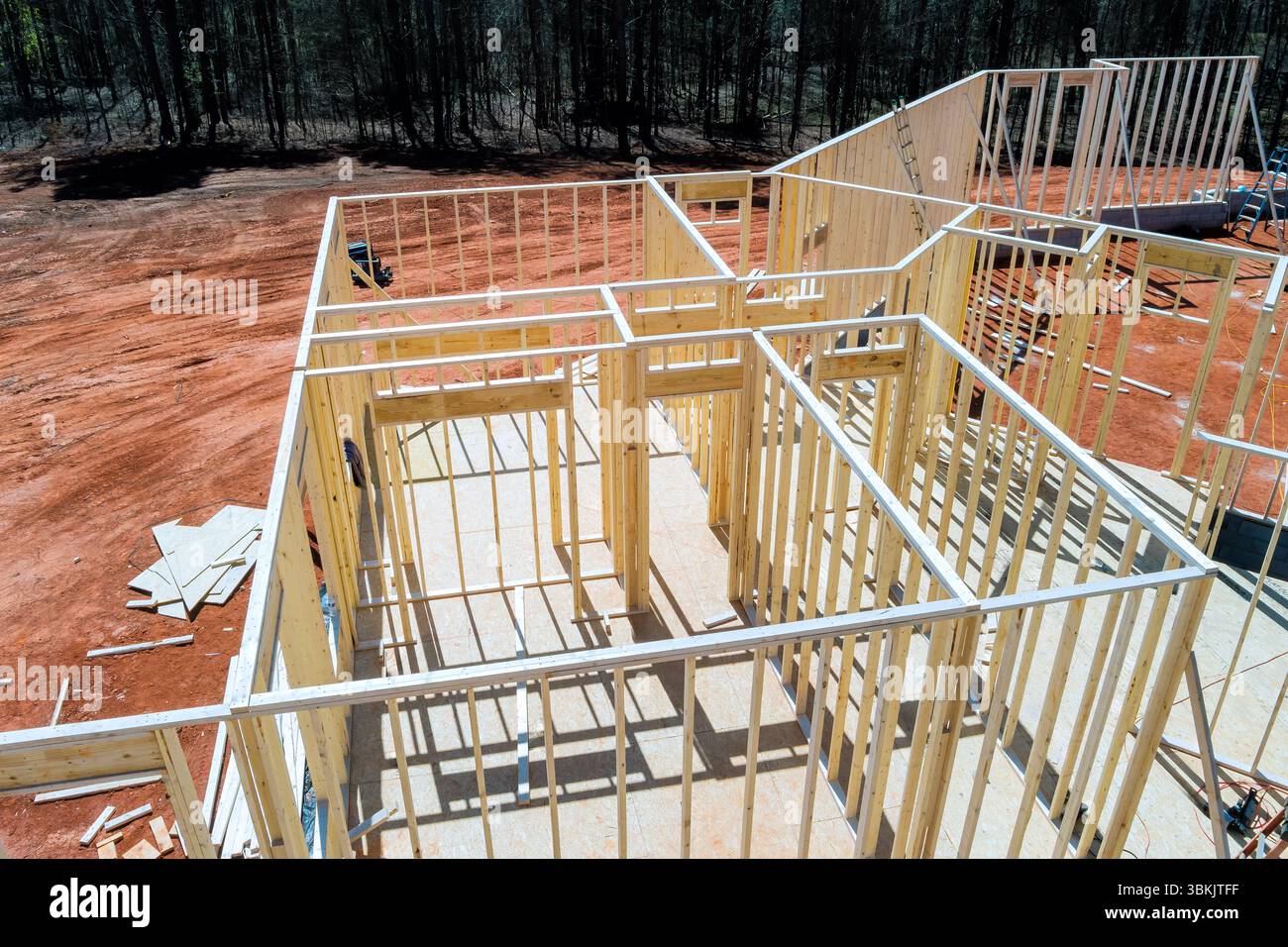 L'appaltatore sta assemblando telai in legno per nuove case in cantiere nel paesaggio di località suburbane Foto Stock