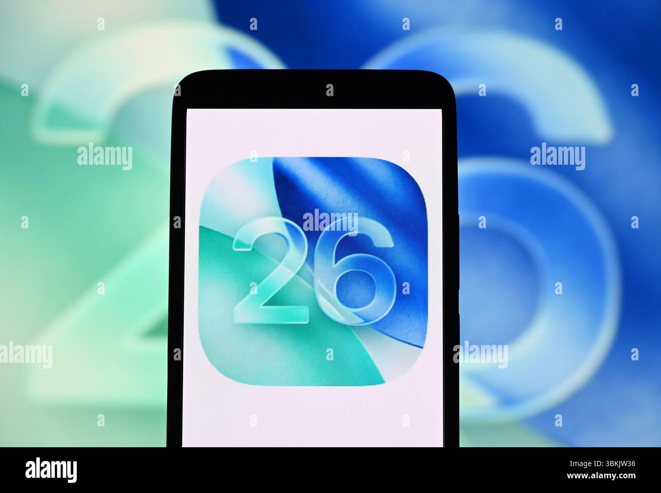 In questa immagine, il logo iOS 26 è visibile su uno smartphone e sullo sfondo. Foto Stock