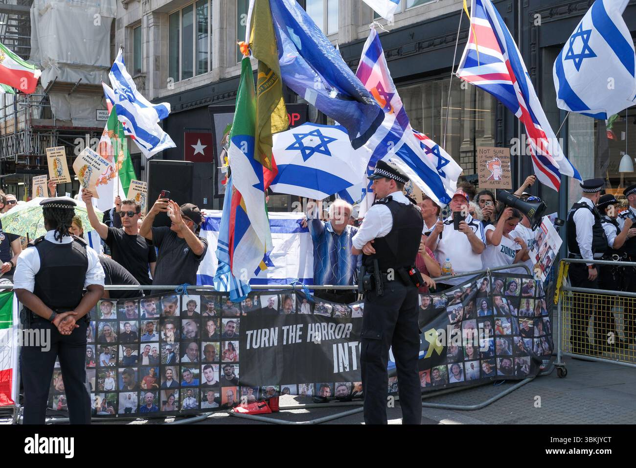 Londra, Regno Unito. 21 giugno 2025. Migliaia di dimostranti di solidarietà palestinesi marciano attraverso il centro di Londra. Una contro-protesta statica organizzata dal gruppo pro-Israele, Stop the Hate, si svolge vicino al percorso di marcia. Nella foto: I manifestanti pro-Israele Uniti dagli oppositori del regime del governo iraniano si preparano alla marcia di solidarietà palestinese. Foto Stock