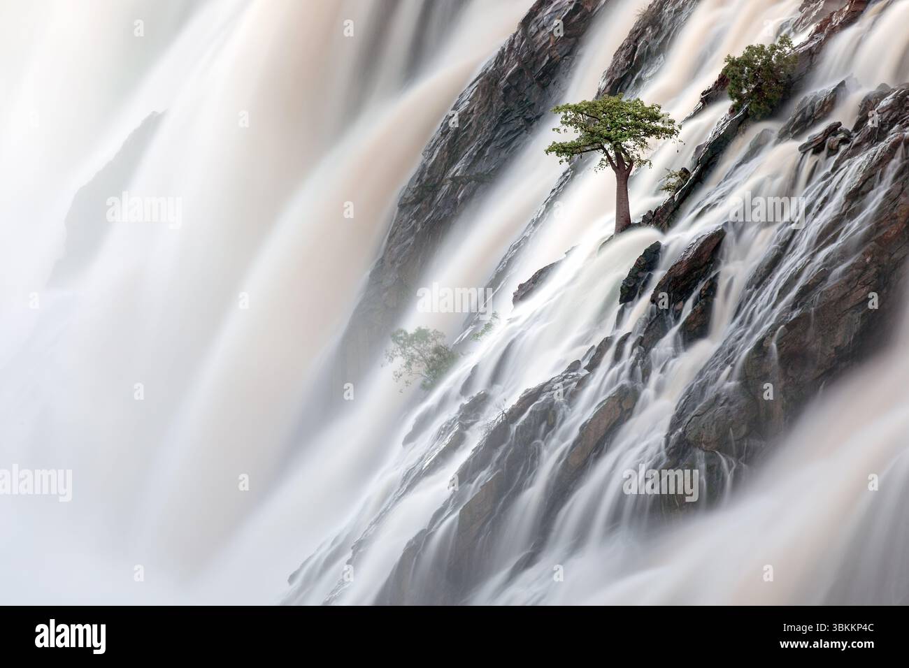 Le acque alluvionali del fiume Kunene scorrono sulle cascate Ruacana, il confine internazionale tra Namibia e Angola. Foto Stock