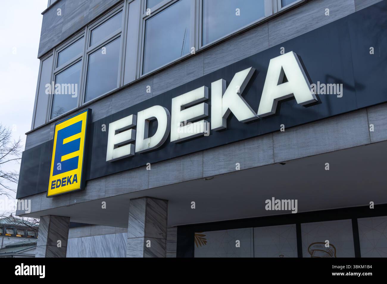 Il moderno logo del supermercato EDEKA è visibile all'esterno di un edificio commerciale in Germania, con il logo e la facciata architettonica. Berlino, Germania. Foto Stock
