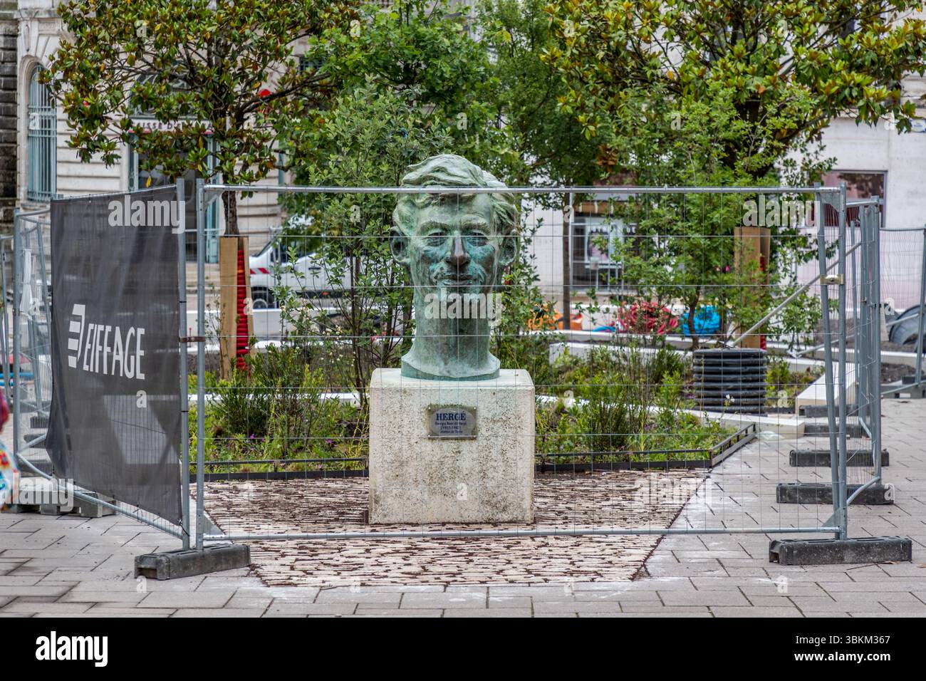 Statua del fumettista belga Georges Prosper Remi. "Hergé" è lo pseudonimo di un artista derivato dalla pronuncia francese delle sue iniziali "RG" (per Remi Georges) invertite. Questo pseudonimo divenne il marchio di fabbrica del suo lavoro, con il quale creò la famosa serie a fumetti "Tintin". Hergé è considerato il fondatore dello stile "Ligne claire", che utilizza contorni chiari senza ombreggiature e semplici campi di colore. Il suo lavoro ha avuto un'influenza significativa sulla cultura comica europea. Lo pseudonimo "Hergé" è quindi indissolubilmente legato alla sua identità artistica e al suo lavoro che definisce lo stile. Busto di Hergé, Foto Stock Statua del fumettista belga Georges Prosper Remi. "Hergé" è lo pseudonimo di un artista derivato dalla pronuncia francese delle sue iniziali "RG" (per Remi Georges) invertite. Questo pseudonimo divenne il marchio di fabbrica del suo lavoro, con il quale creò la famosa serie a fumetti "Tintin". Hergé è considerato il fondatore dello stile "Ligne claire", che utilizza contorni chiari senza ombreggiature e semplici campi di colore. Il suo lavoro ha avuto un'influenza significativa sulla cultura comica europea. Lo pseudonimo "Hergé" è quindi indissolubilmente legato alla sua identità artistica e al suo lavoro che definisce lo stile. Busto di Hergé, Foto Stock